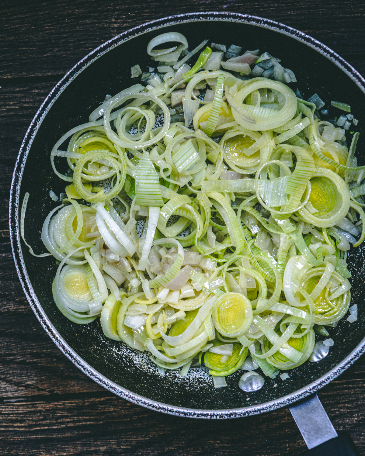 adding leeks and shallots to a pan with olive oil and garlic